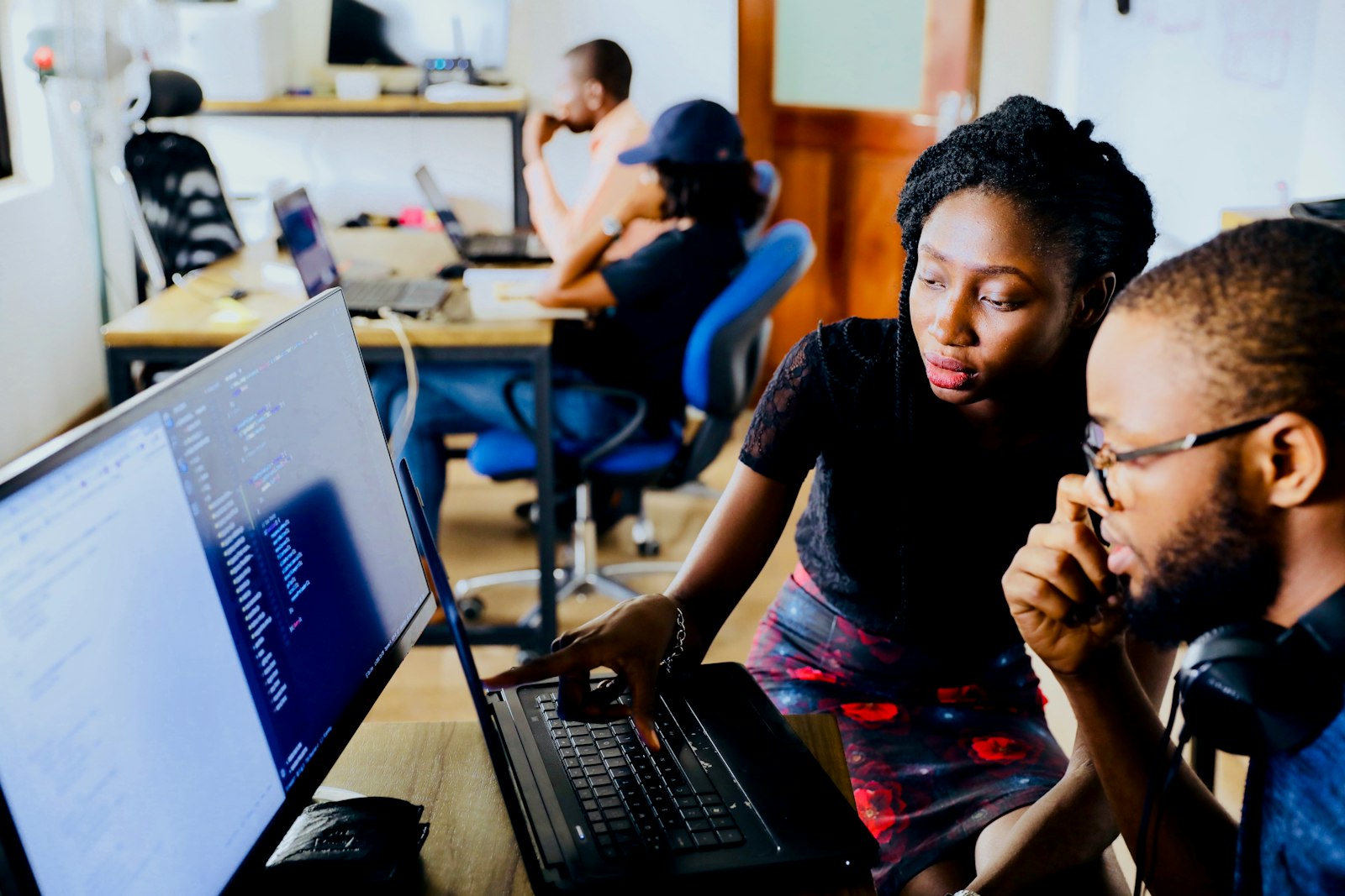 Dos personas resolviendo una consulta frente al computador